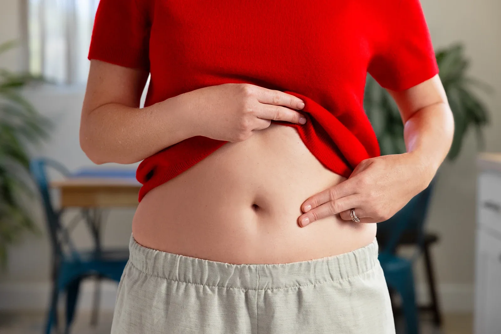 A woman pointing to her abdomen area