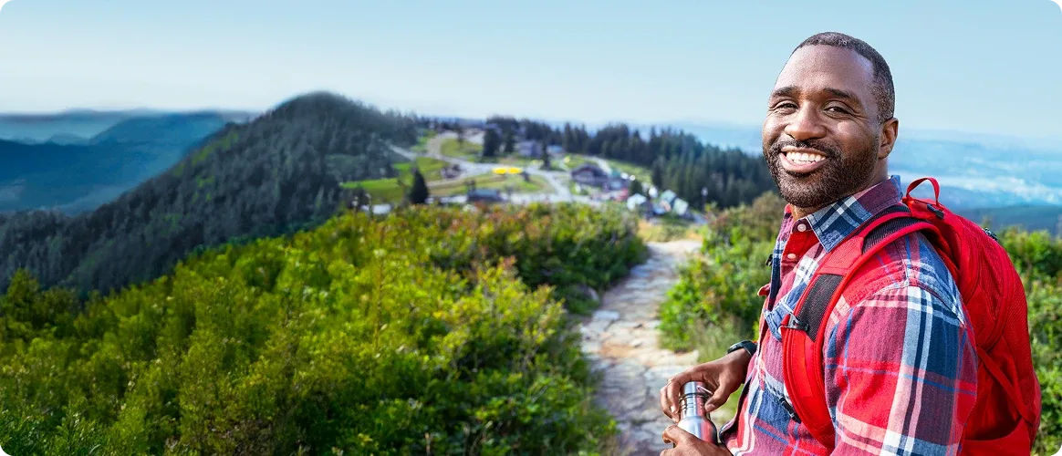 A man smiling and hiking outdoors