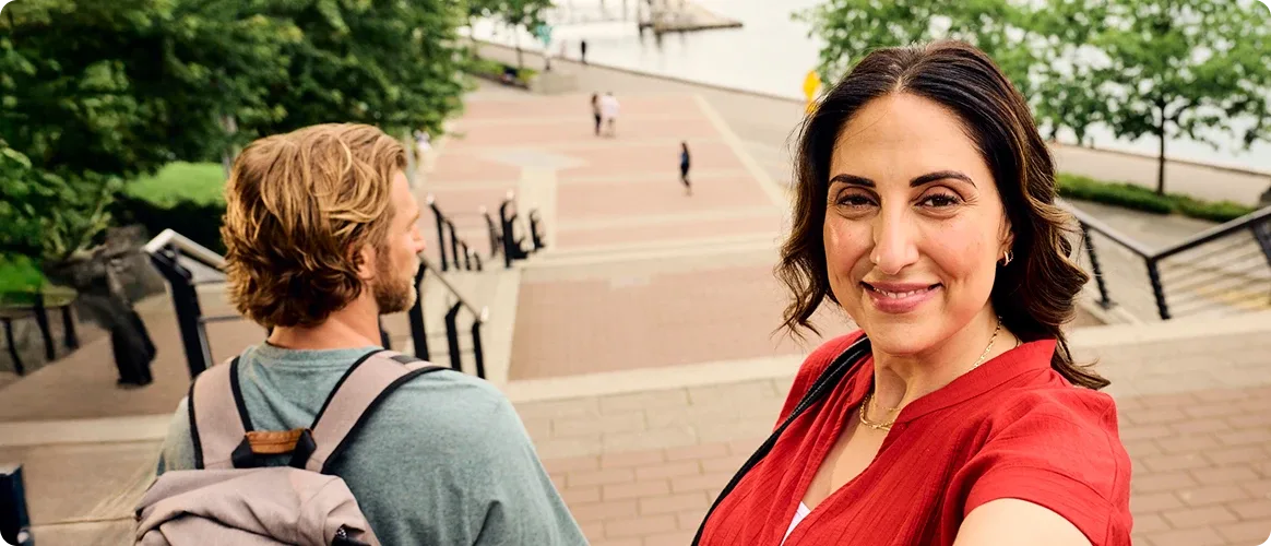 A woman taking a selfie at the top of the stairs outdoors