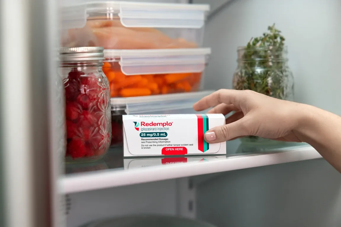 A hand grabbing their packaged Redemplo® (plozasiran) medication from their fridge