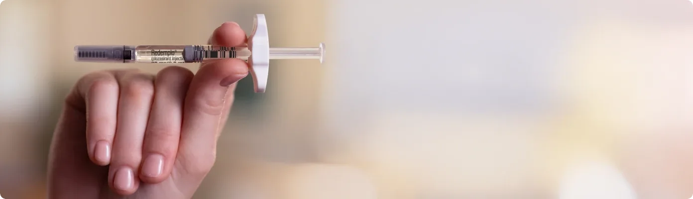 A hand holding a Redemplo® (plozasiran) injector pen