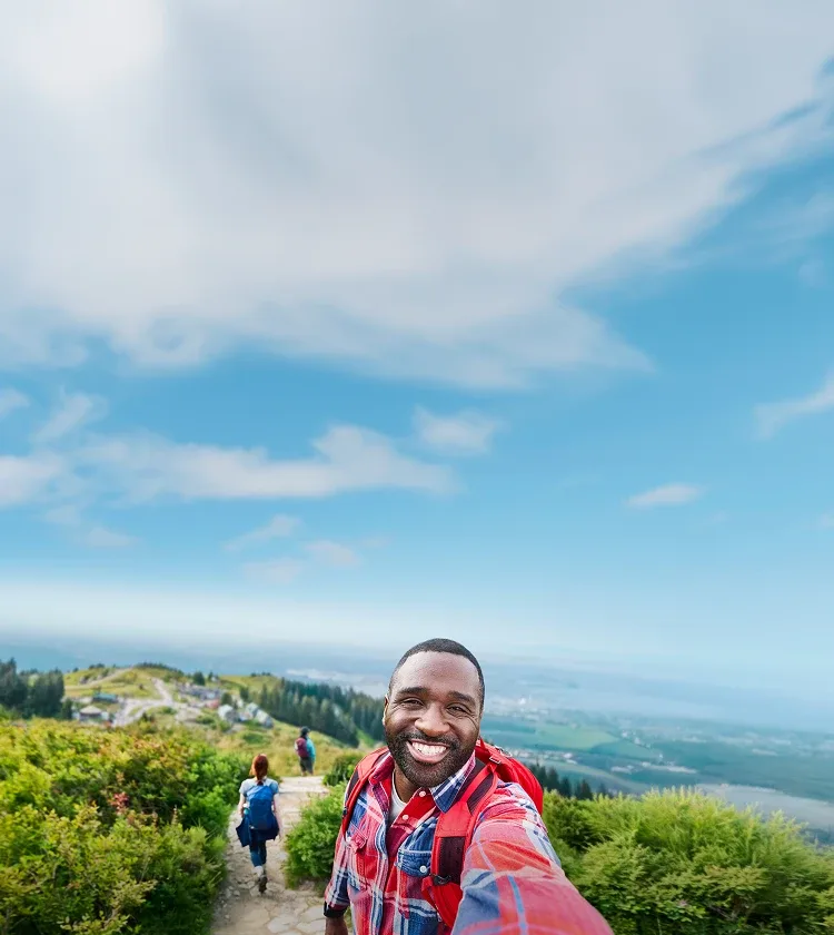 A man smiling and hiking outdoors