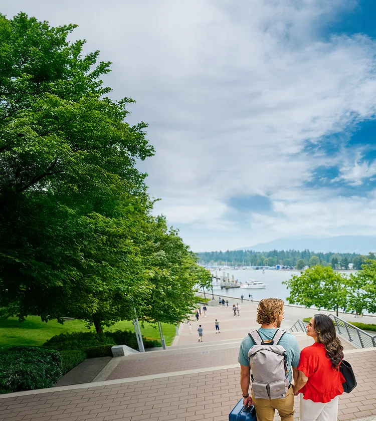 A man and a woman holding hands at the top of the stairs outdoors
