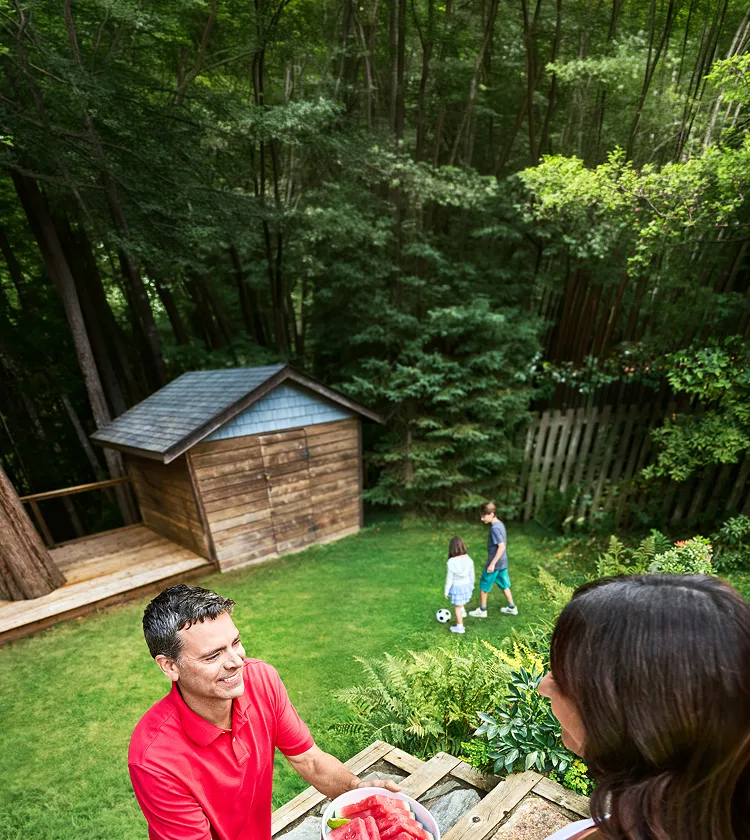 A man handing a bowl of watermelon to a woman